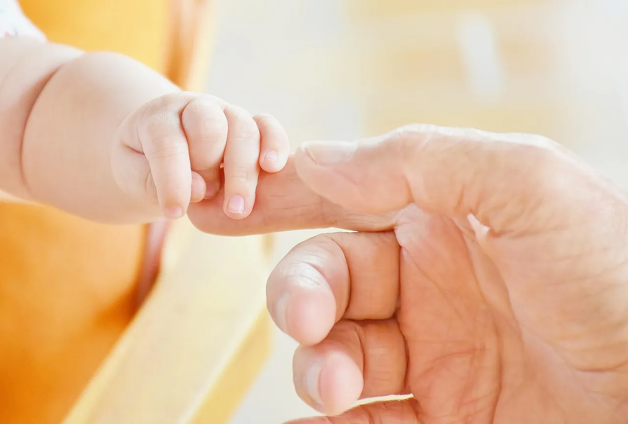 Babyhand hält den Finger eines Erwachsenen